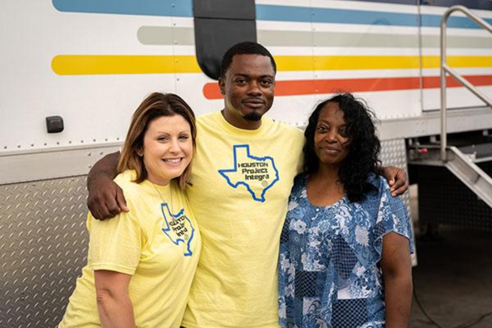 Peer navigator coach, Kristina Davis (left), Frank Williams (middle), and Frank's mother, Alysia Williams (right), pose in front of the INTEGRA van. (Photo by UTHealth Houston)
